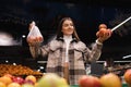 Eco friendly woman buys apples in the supermarket. Female grocery shopper opposes the use of plastic bags. Royalty Free Stock Photo