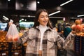 Eco friendly woman buys apples in the supermarket. Female grocery shopper opposes the use of plastic bags. Royalty Free Stock Photo