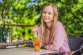 Eco friendly woman using reusable stainless steel straw to drink fruit tea