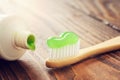 Eco friendly wooden bamboo toothbrush with toothpaste and tube of toothpaste closeup