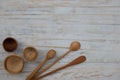 Eco-friendly wooden bowls, spoons and honey stick on wooden table background. Environmentally friendly kitchen utensil flat lay Royalty Free Stock Photo