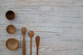 Eco-friendly wooden bowls, spoons and honey stick on wooden table background. Environmentally friendly tableware flat lay with Royalty Free Stock Photo