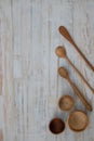 Eco-friendly wooden bowls, spoons and honey stick on wooden table background. Environmentally friendly tableware flat lay with Royalty Free Stock Photo