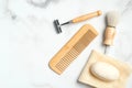 Eco-friendly wooden shaving accessories for man on marble table. Flat lay, top view