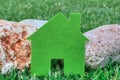 Eco house concept in a green grass and stones, green eco house icon in nature Royalty Free Stock Photo