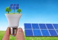 Eco LED light bulb with solar panels in hand. Royalty Free Stock Photo