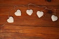 Eco linen fabric hearts on wooden background,Valentines Day concept design.Decorative white heart on jute twine garland