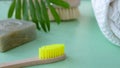 Eco natural bamboo toothbrush on green background with toiletries, natural soap, body brush and waffle towel. Zero waste Royalty Free Stock Photo