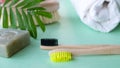 Eco natural bamboo toothbrush on green background with toiletries, natural soap, body brush and waffle towel. Zero waste Royalty Free Stock Photo