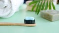 Eco natural bamboo toothbrush with toothpaste on green background with toiletries, natural soap, body brush and waffle Royalty Free Stock Photo