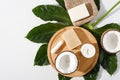 Eco organic cosmetic on wooden board on white background, natural handmade soap, cream, hygienic lipstick, coconut, green leaf, Royalty Free Stock Photo