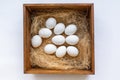 Eco-product. A wooden box of hay containing a ten white eggs. View from the top. Flat lay. White background. Concept of natural