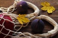 Eco shopping, zero waste concept. Eco-friendly string bag with figs and red apple on a wooden autumn background with