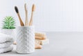 Eco toothbrushes. Bamboo toothbrushes cup, natural soap, wooden hair brush and white towels on gray stone background Royalty Free Stock Photo