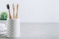 Eco toothbrushes. Bamboo toothbrushes cup, white towels on gray stone background Royalty Free Stock Photo