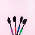 Eco toothbrushes made of bio degradable plastic and bamboo active charcoal on pink background