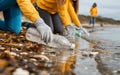 eco volunteers picking up plastic trash on the beach - Activist people collecting garbage protecting the planet - Ocean Royalty Free Stock Photo
