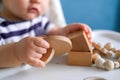 Eco wood toys. baby game. Little clever caucasian child playing natural toys on highchair. games for early development