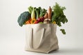 Ecologic bag full of fresh organic vegetables over white background.