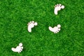 Ecological concept representing wooden footprints on grass