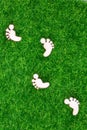 Ecological concept representing wooden footprints on grass