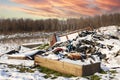 Ecological crisis. Different garbage and trash on snow at beautiful winter forest at colorful sky. Environmental pollution by