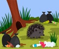 Ecological disaster from plastic waste in the forest. a cute hedgehog near his mink on the background of a landfill and Royalty Free Stock Photo