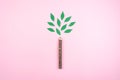 Ecological friendly, sustainable environment, Eco conscious concept with pen in the form of a tree trunk with green leaves on pink