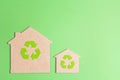 Ecological houses with recycling symbol on green background