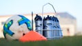 Ecological sport bottles of fresh water on football field grass. Blurred soccer ball and cone. Royalty Free Stock Photo