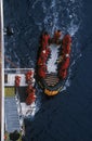 Ecological tourists enter inflatable Zodiac boat from cruise ship Marco Polo in Errera Channel at Culberville Island, Antarctica