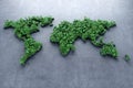 Ecological world map consisting of green grass and tropical leaves on concrete background. Concept of recycling garbage, air Royalty Free Stock Photo