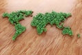 Ecological world map consisting of green grass and tropical leaves on wooden background. Concept of recycling garbage, air Royalty Free Stock Photo