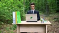 Ecologist creating eco saving project, sitting in forest, deforestation concept