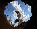 Ecologist digging pit by shovel and planting tree