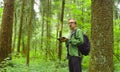 The ecologist in a forest writing in notebook.