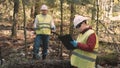 Ecologist man in workwear and helmet clean plastic garbage in forest