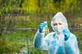 Ecologist with samples of water and plants from the forest river conducts