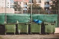 Ecology concept. Green metal trashcan with waste. Large plastic wheelie bins for rubbish, recycling and garden waste