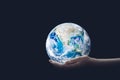 Ecology Concept : Hand holding blue planet earth in dark room. Royalty Free Stock Photo