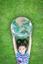 Ecology concept with happy kid raising green globe on eco friendly green grass lawn. Element of image furnished by NASA