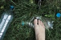 Ecology concept. Human foot crushes a plastic bottle on grass. Royalty Free Stock Photo