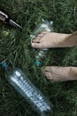 Ecology concept. Human foot crushes a plastic bottle on grass. Royalty Free Stock Photo