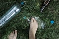 Ecology concept. Human foot crushes a plastic bottle on grass. Royalty Free Stock Photo