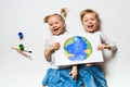 Ecology concept with two prety little kids painting earth on white background