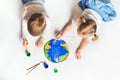 Ecology concept with two prety little kids painting earth on white background