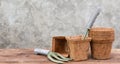 Ecology flower pots made from coconut fiber and shovel on wooden table with cement wall background