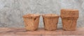 Ecology flower pots made from coconut fiber on wooden table with cement wall background