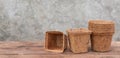 Ecology flower pots made from coconut fiber on wooden table with cement wall background