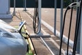 Ecology friendly transport concept. Loading energy. Gray car is charged on electric charging station in parking. Electricity and Royalty Free Stock Photo